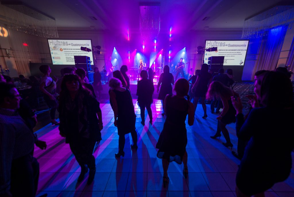 Foule dansante sous des lumières colorées pendant un événement.